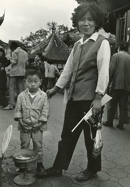 boy peeing in a spittoon mother holding a toy gun