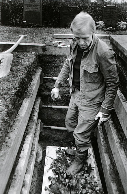 Grave-digger standing on the coffin in the grave