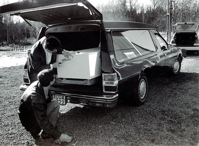 Name tag of the dead father is nailed into the coffin by two sons. the hearse was rented