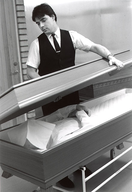 The undertaker closing the coffin with the lid