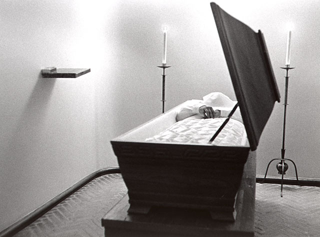 Showingroom with open casket and lit candles