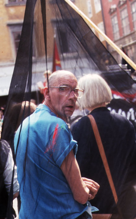 man with big glasses with surprised look behind a translucent black cloth