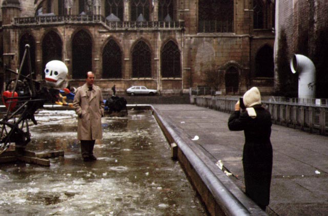 Pris man standing on a frozen pond with statue and skull