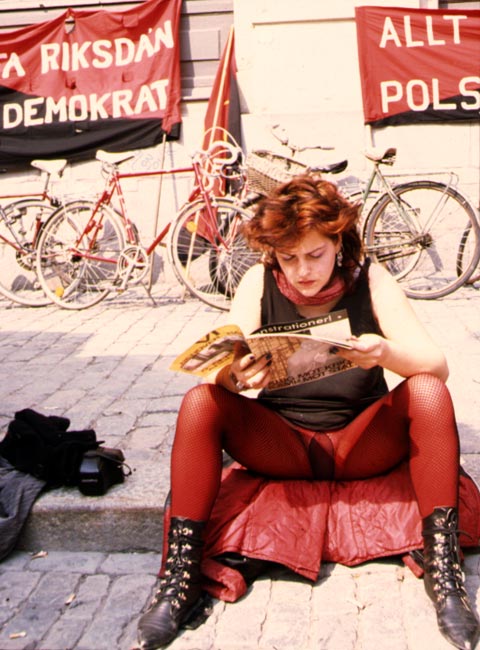 woman with red pantyhose tights and red hair syndicalist demonstration on mayday in Stockholm Sweden