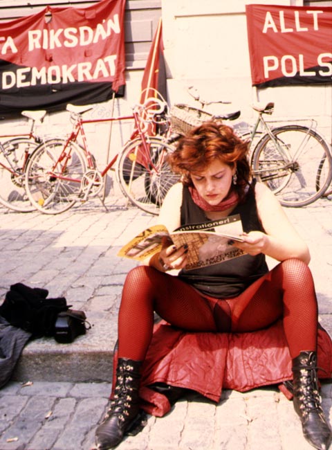 woman with red pantyhose tights and red hair syndicalist demonstration on mayday in Stockholm Sweden