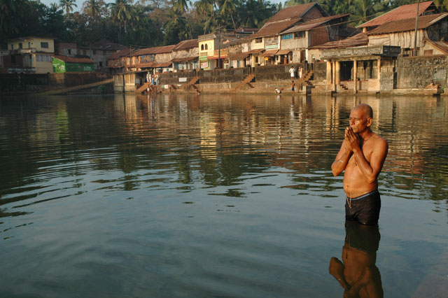 pilgrim praying in sun rise in the holy pool Gokarna India hindu meditation