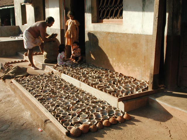 Brahmin drying coconuts on his front porch