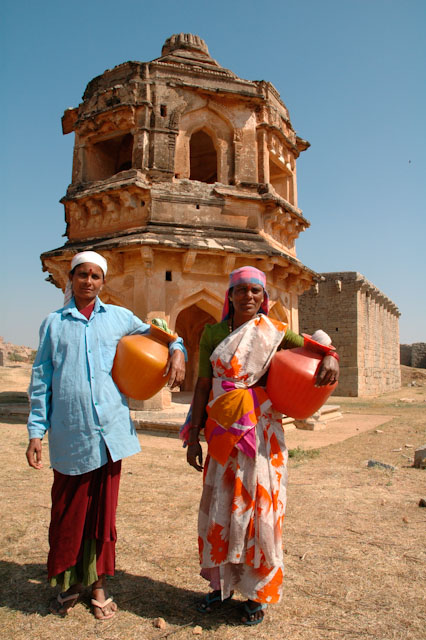 hampi archeological excavation workers with temple ruins in the background