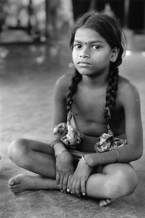 farmer girl in Kudle india sitting relaxed on floor with beautiful eyes and hair in braids