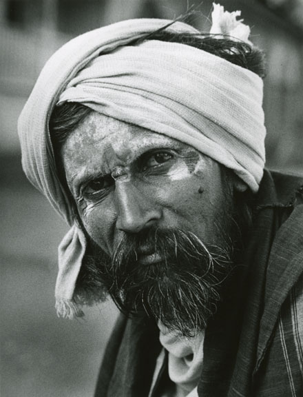 Sadhu with intense look turban beard face painted with chalk