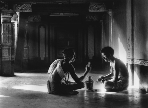 Shiva Temple in Gokarna brahmin giving instuctions to pilgrim inside of temple with shiny marble floor spectacular morning light filtering through the air light reflections in the face