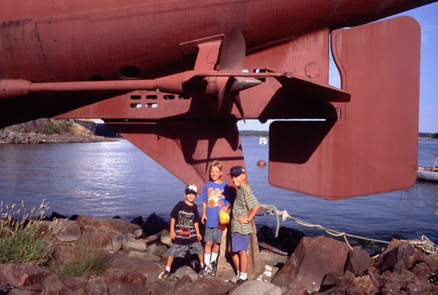 three boys by the submarine in Sveaborg, Suomenlinna, summer in Helsinki midnight sun