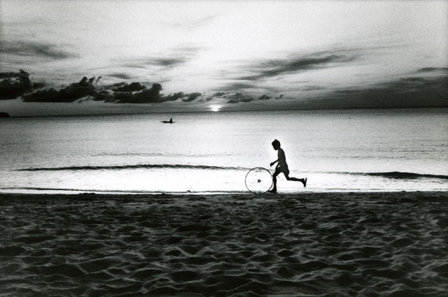 boy spinning a wheel on beach by sunset in Boracay Philippines