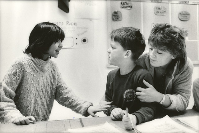 Teacher and a girl student trying to calm down an angry boy student