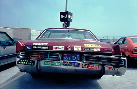 Old car with lots of bumper stickers