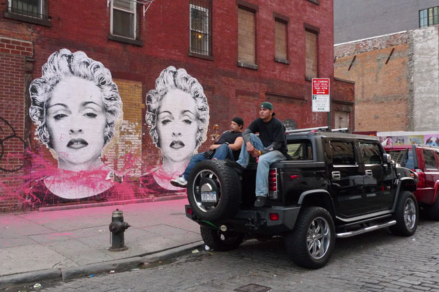 two men sit on a car next to mural of Madonna or Marilyn Monroe usv boys girls red blond albino