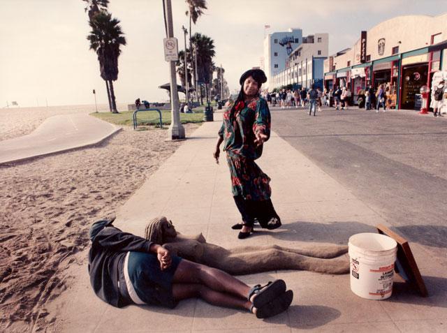 Nude female sand statue with artist next to her Venice beach